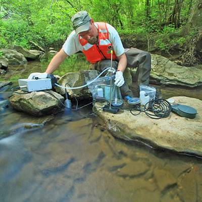Filtering a manually collected water sample (grab sample) for analysis